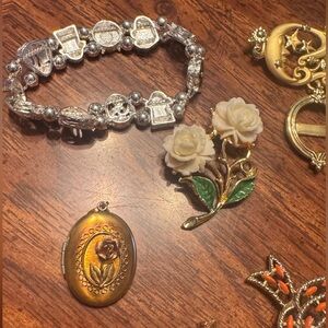 Multi bag of pins, a locket and a sailing bracelet.